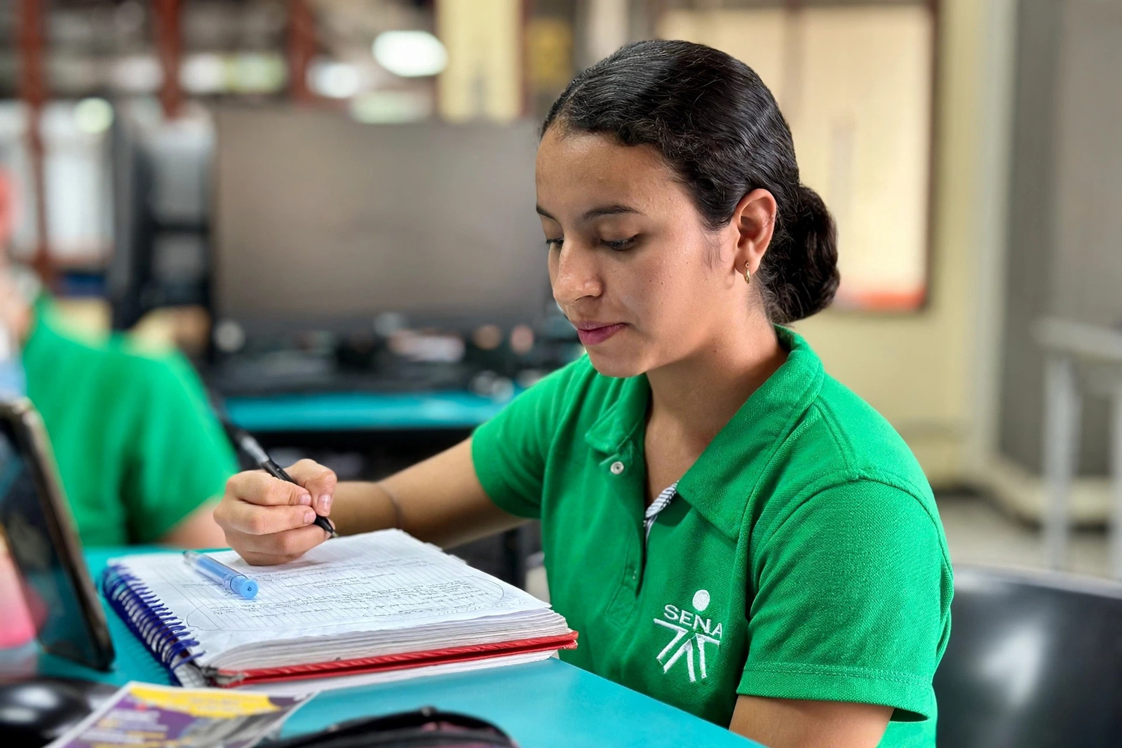 Aprendiz registrando notas de evaluación de software en su cuaderno